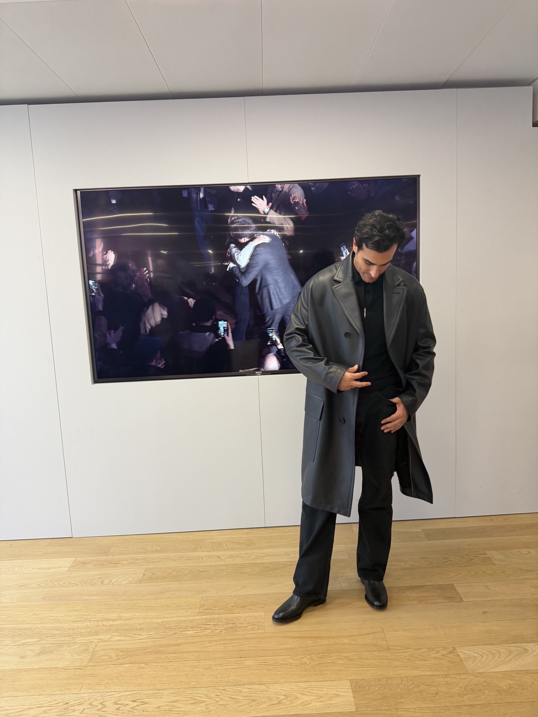 Ali Hennaoui trying on a long Hermès leather coat from the Fall/Winter 2026 collection