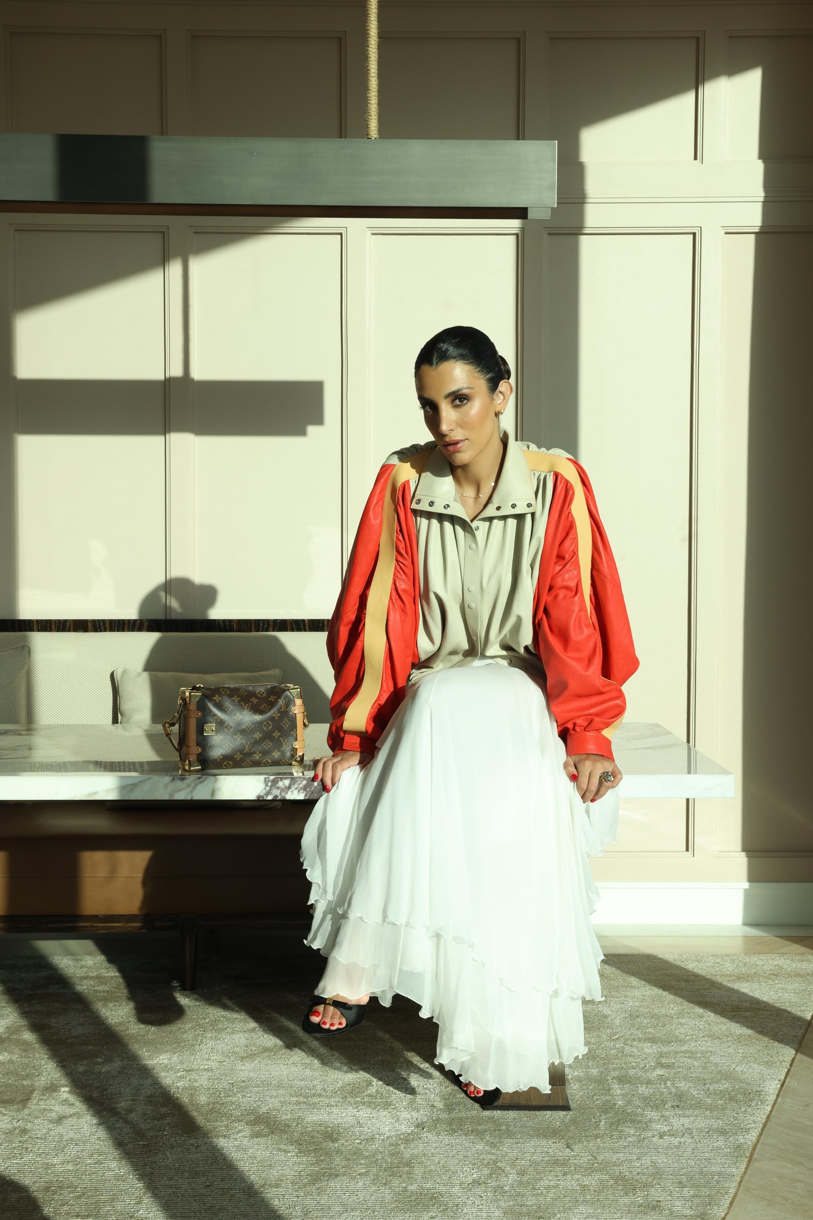 Walaa Awada in a Louis Vuitton colorblock leather jacket
      at The Lana, Dubai — Louis Vuitton campaign by Ali & Walaa,
      May 2025