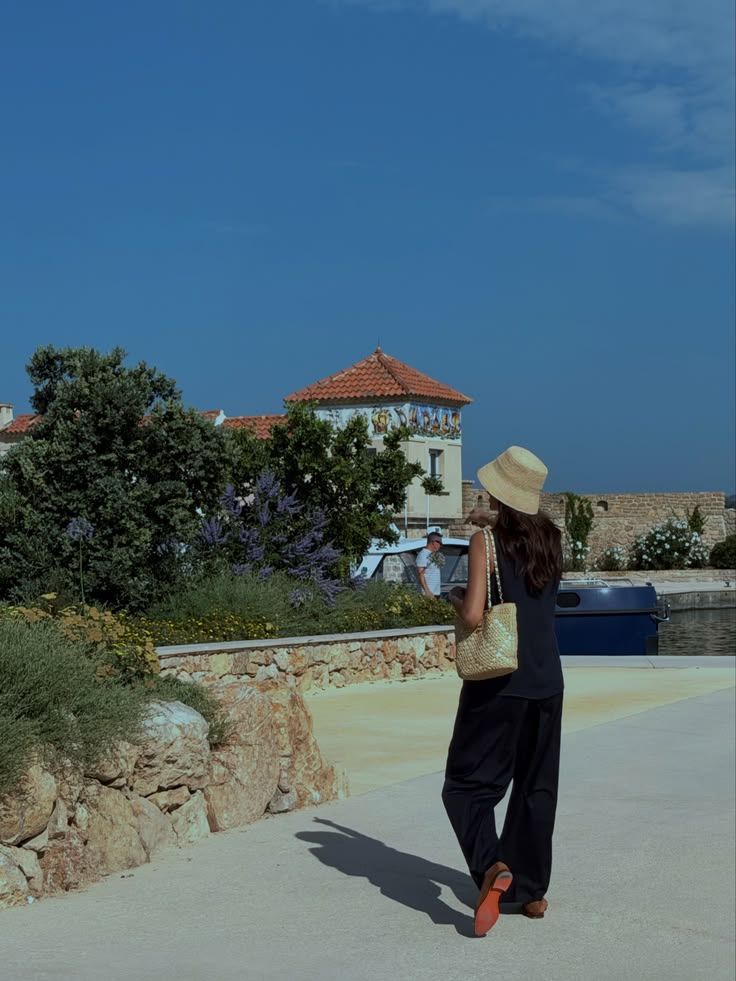 Walaa Awada walking at the port in a black outfit and bucket hat,
    Côte d'Azur — Mercedes-Maybach experience lifestyle content by Ali & Walaa