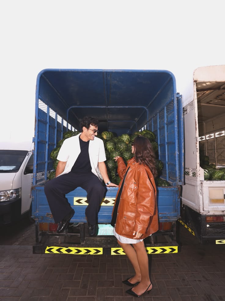 Ali Hennaoui and Walaa Awada laughing together inside
      a watermelon delivery truck at Ras Al Khor market —
      Prada SS26 campaign by Ali & Walaa, Dubai 2026